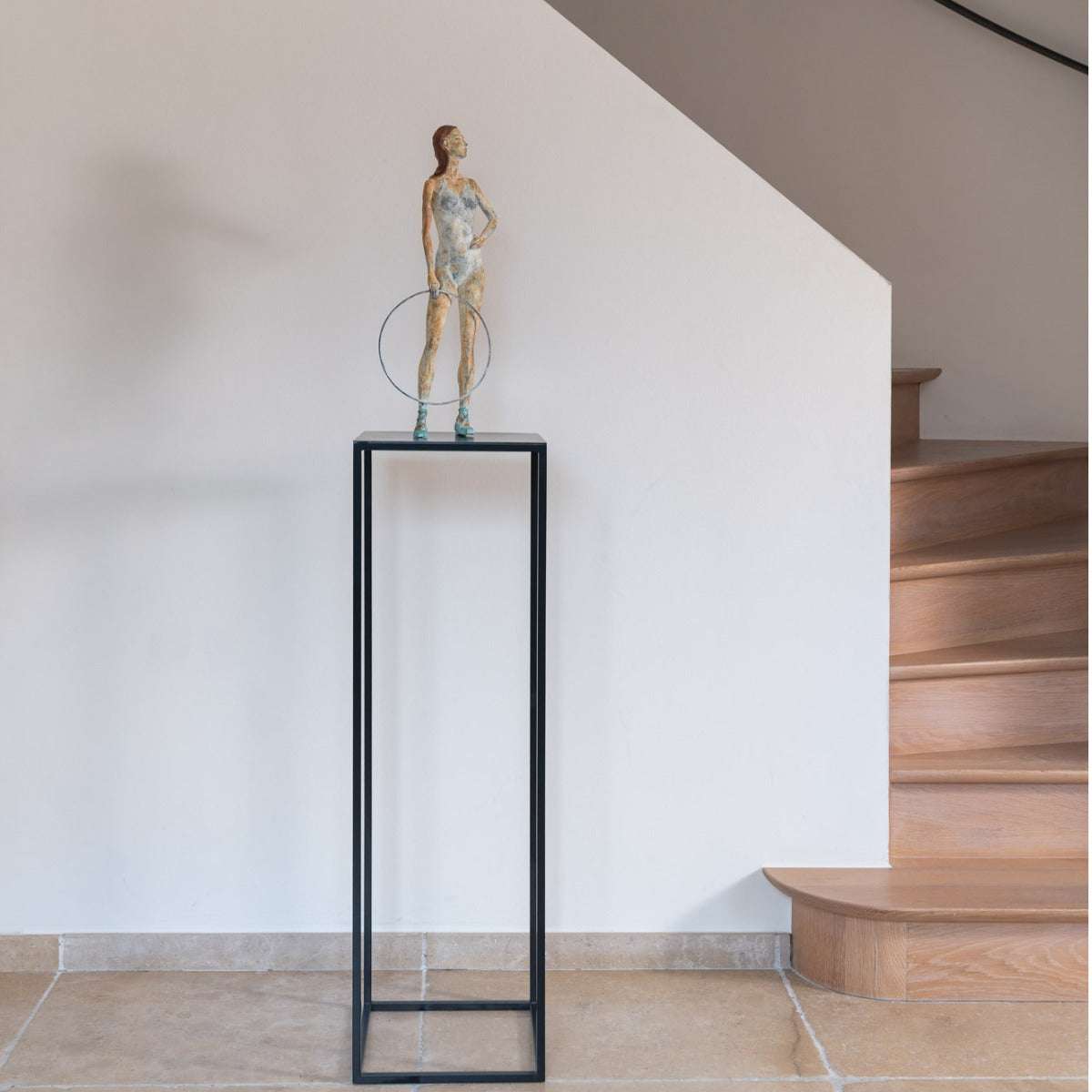 Bronzeskulptur "Celeste" von Raffaella Benetti auf einer Metall Säule vor einer Treppe