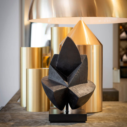 Musing Skulptur auf Sockel vor Lampe